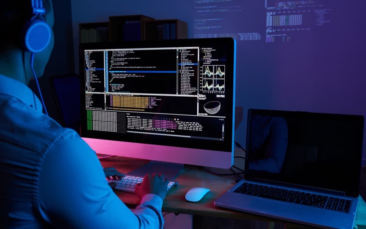 Engineer reviewing code on screen in a dark office